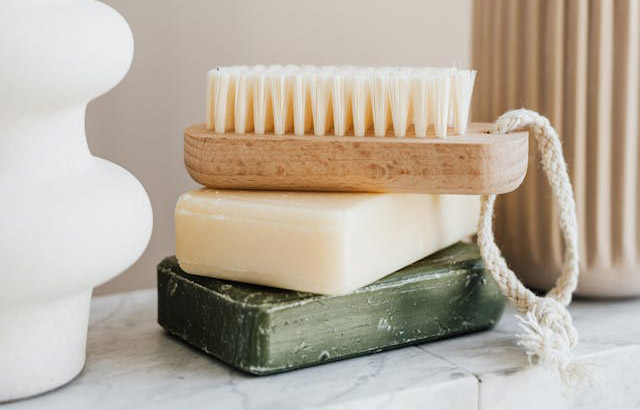 two bars of soap stacked with a brush